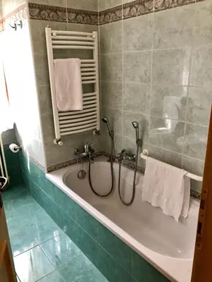 a bathroom with a tub with a mirror and towels at Stella Alpina in Voltago