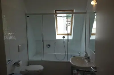 a bathroom with a shower and a toilet and a sink at Hager Apartment 2 in Merano