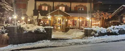 a building covered in snow at night with lights at Villa Martha Vintage Hotel-B&B in Santa Cristina in Val Gardena