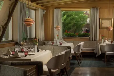 a restaurant with tables and chairs and a window at Hotel Genziana in Selva di Val Gardena