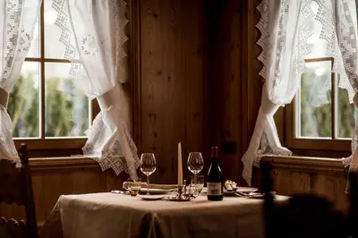 a table with wine glasses and wine bottles on it at Hotel Genziana in Selva di Val Gardena