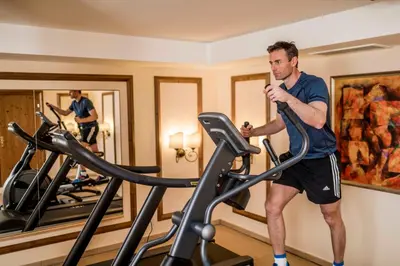 a man on a treadmill in a gym at Hotel Genziana in Selva di Val Gardena