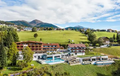 a building with a pool in the snow at Parkhotel Holzerhof in Maranza