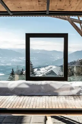 a village in the snow with mountains in the background at Parkhotel Holzerhof in Maranza