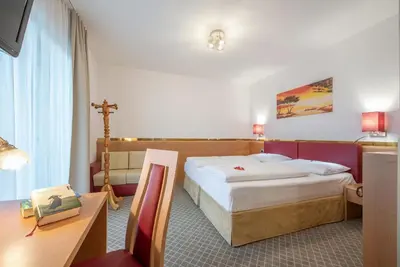 a hotel room with a bed and a desk at Hotel Hubertushof in Naz-Sciaves