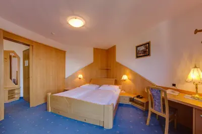a hotel room with a bed and a desk and a desk at Hotel Hubertushof in Naz-Sciaves