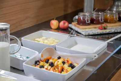 a buffet with three trays of food on a counter at Hotel Hubertushof in Naz-Sciaves