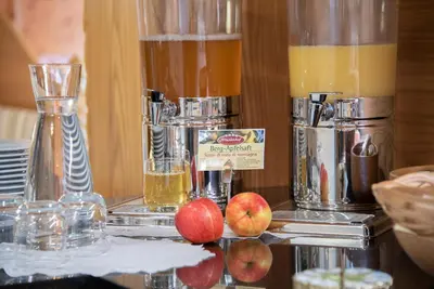a counter with some drinks and apples on a table at Hotel Hubertushof in Naz-Sciaves