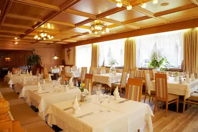a dining room with white tables and chairs at Hotel Hubertushof in Naz-Sciaves