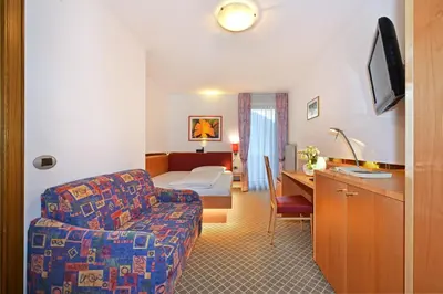 a hotel room with a couch and a bedroom at Hotel Hubertushof in Naz-Sciaves