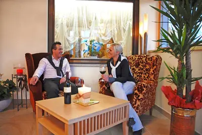 a man and a woman sitting in chairs with wine glasses at Hotel Hubertushof in Naz-Sciaves