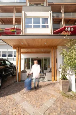 a man is walking in front of a building at Hotel Panoramik in Mühlbach