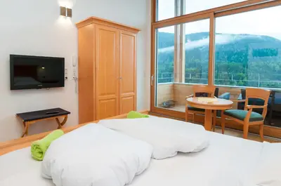 a bedroom with a bed and a large window at Hotel Panoramik in Mühlbach