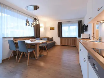 a kitchen and living room with a table and chairs at Residence Hotel Fever in Ortisei