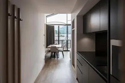 a kitchen with black cabinets and a dining room at Residence Hotel Fever in Ortisei