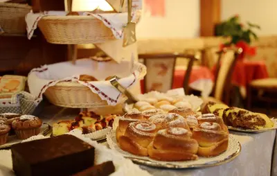a table with various pastries and cakes and other desserts at Residence Hotel Fever in Ortisei