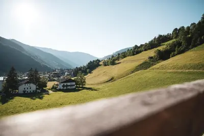 a view of a valley with houses on a hill at BergHotel Majarei in San Vigilio Di Marebbe
