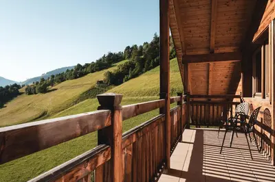 a porch of a cabin with a view of the mountains at BergHotel Majarei in San Vigilio Di Marebbe