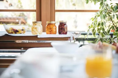 a table with jars and a plate of oranges at BergHotel Majarei in San Vigilio Di Marebbe