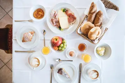 a white table with plates of food on it at BergHotel Majarei in San Vigilio Di Marebbe
