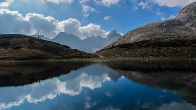 a view of a lake with mountains in the background at BergHotel Majarei in San Vigilio Di Marebbe