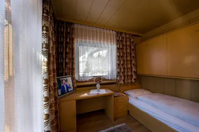 a bedroom with a bed and a large window at Pensione Haus Erica in Colfosco