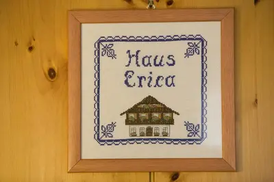 a table with two glasses of wine and a plate of food at Pensione Haus Erica in Colfosco