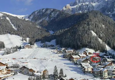 a group of people skiing down a snow covered slope at Garni Hotel Mezdi in Selva di Val Gardena