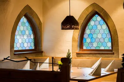 a dining room with two stained glass windows at Hotel Residence Gasser in Villandro