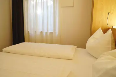 a bed with a pillow on it with a window at Residence Larciunei in Ortisei