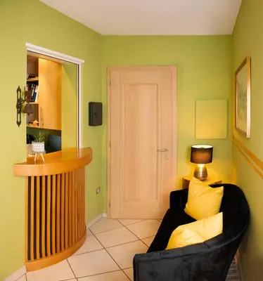 a living room with a black couch and a lamp at Villa Gottfried B&B in Eggen