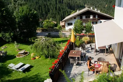a woman sitting at a table on a balcony at Villa Gottfried B&B in Eggen