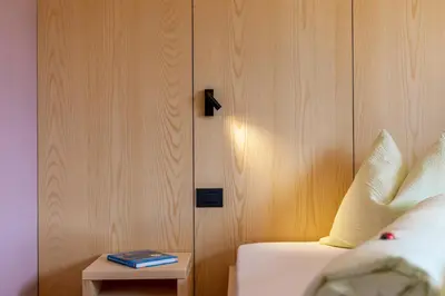 a room with a bed and a table with a book at Villa Gottfried B&B in Eggen
