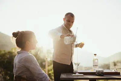 a man pouring a glass of wine for a woman at Hotel Mareo Dolomites in San Vigilio Di Marebbe
