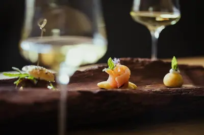 a plate of food with a glass of wine at Hotel Mareo Dolomites in San Vigilio Di Marebbe