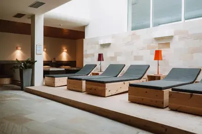 a waiting room with a row of chairs and tables at Boutique-Hotel Ballguthof am Golfplatz in Lana