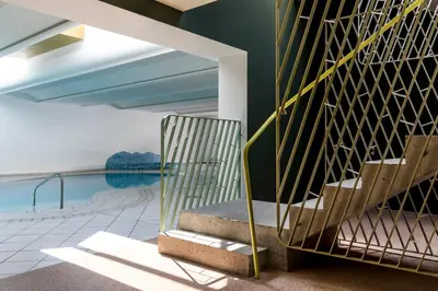 a staircase in a house with a pool at Boutique-Hotel Ballguthof am Golfplatz in Lana