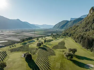 an aerial view of a golf course with mountains in the background at Boutique-Hotel Ballguthof am Golfplatz in Lana