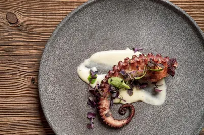 a plate of food with an octopus on it at Piccolo - Dolomites & Gourmet Hotel in Selva di Val Gardena