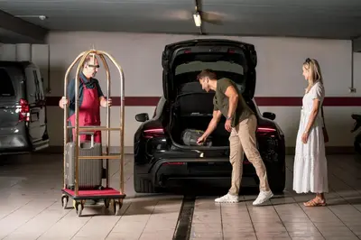 a man and a woman standing next to a car at Piccolo - Dolomites & Gourmet Hotel in Selva di Val Gardena