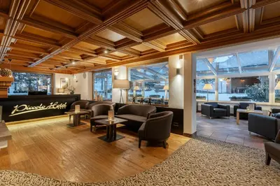 a lobby of a hotel with couches and chairs at Piccolo - Dolomites & Gourmet Hotel in Selva di Val Gardena