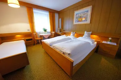 a large bedroom with two beds and a window at Ciasa Complojer in La Valle