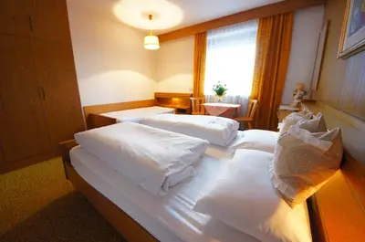 a bedroom with two beds with white pillows at Ciasa Complojer in La Valle