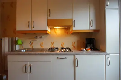a kitchen with white cabinets and a sink at Ciasa Complojer in La Valle