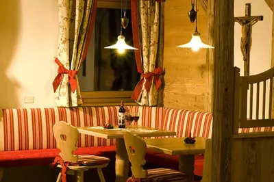 a restaurant with a table and chairs and a mirror at Residence Rumanon in Ortisei