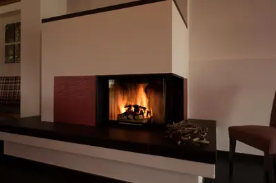 a fireplace in a living room with a fire in it at Panorama Hotel Flora in Villandro