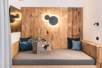 a room with a bench with a bag on it at Hotel Wolf in Selva di Val Gardena