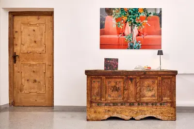 a wooden cabinet next to a door with a painting on the wall at Hotel Walther v.d. Vogelweide Superior in Chiusa