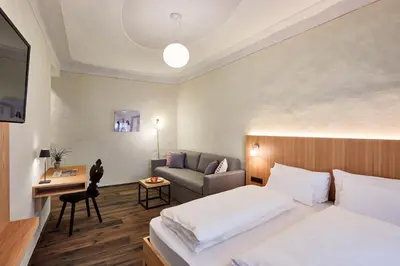 a hotel room with a bed and a couch at Hotel Walther v.d. Vogelweide Superior in Chiusa