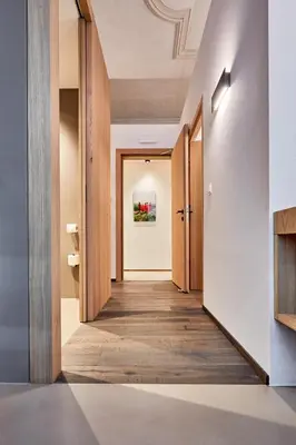a hallway leading to a room with wooden doors at Hotel Walther v.d. Vogelweide Superior in Chiusa